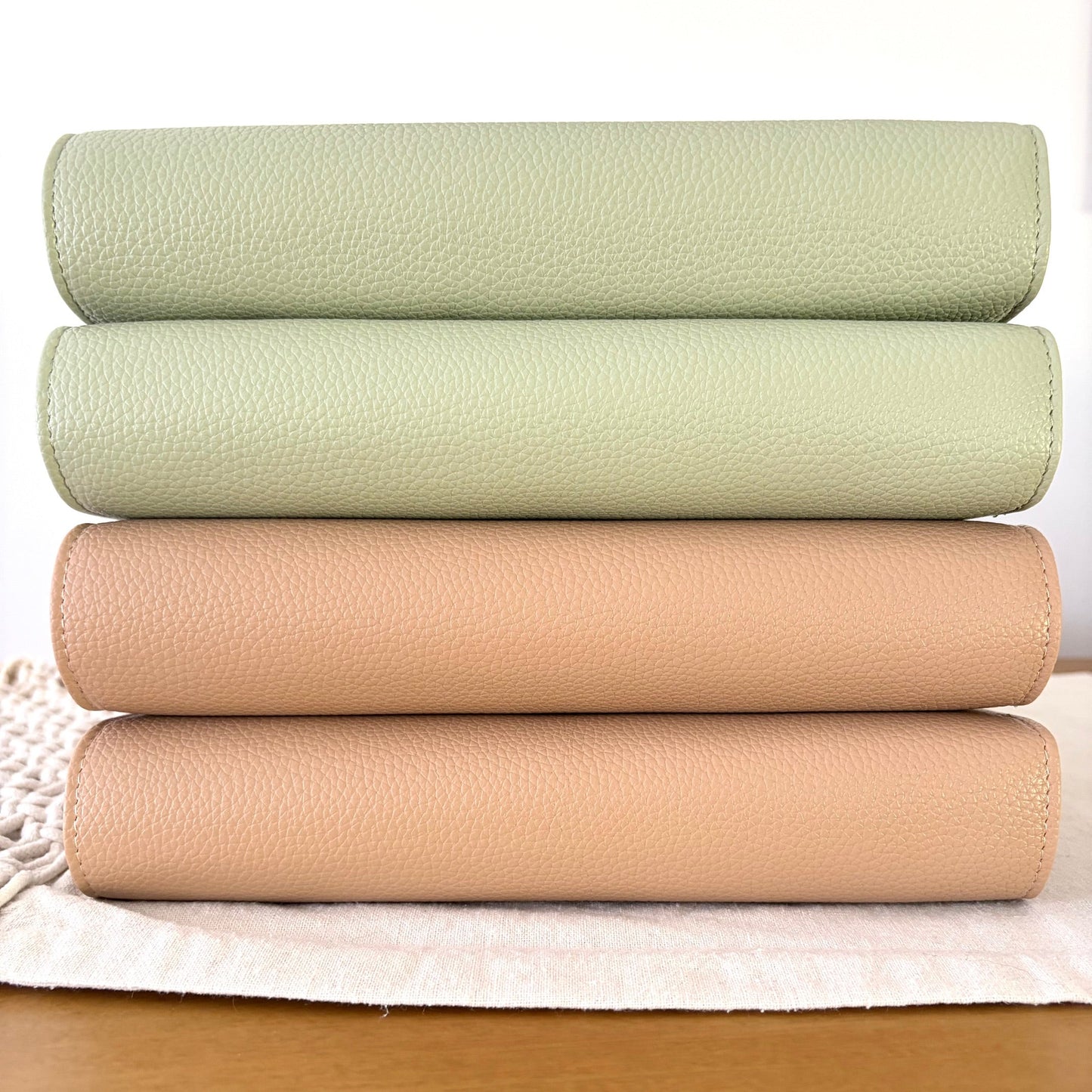 Latte and Sage green binders stacked on a wooden bench