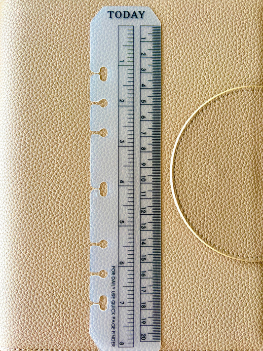 A close-up of a beige textured planner cover with a white plastic divider insert featuring a printed ruler and the word TODAY at the top.