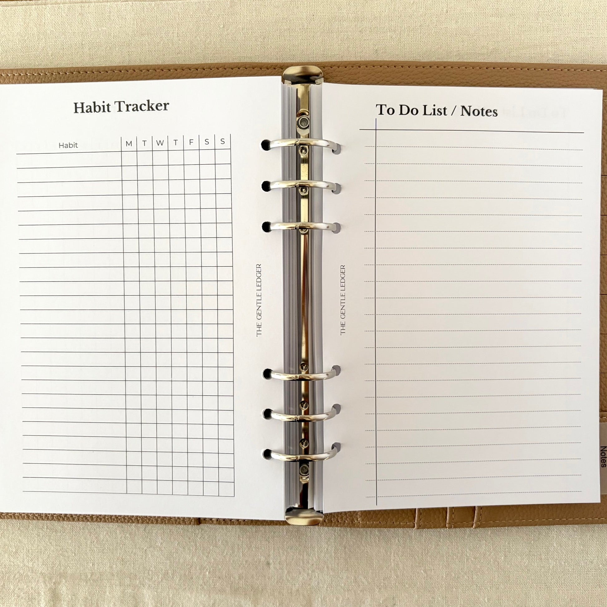 Open planner showing habit tracker and to-do list/notes sections on a wooden surface.