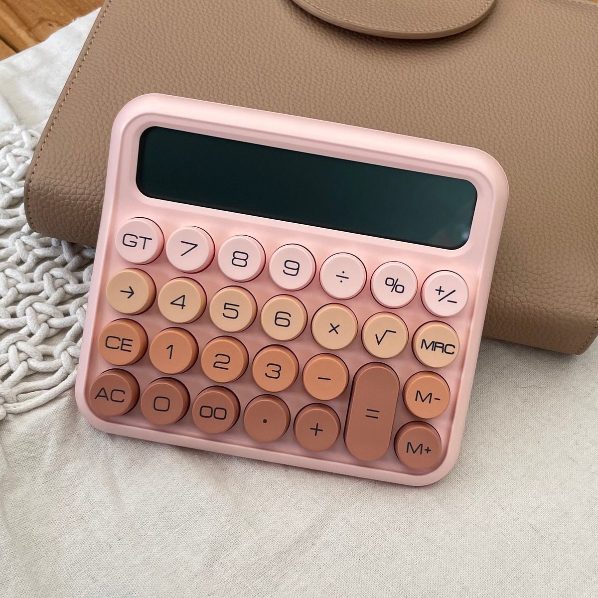 pink calculator on tan book 