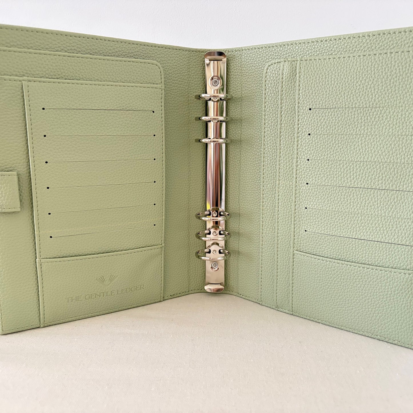Sage green vegan pebble leather 6 ring binder on a white background